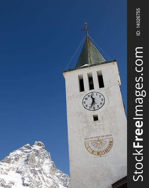 Picture of a bell tower and mount Cervino in background