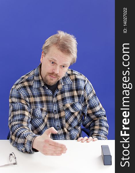 Casually dressed manager (male) points out his opinion at his desk in the office. Casually dressed manager (male) points out his opinion at his desk in the office.