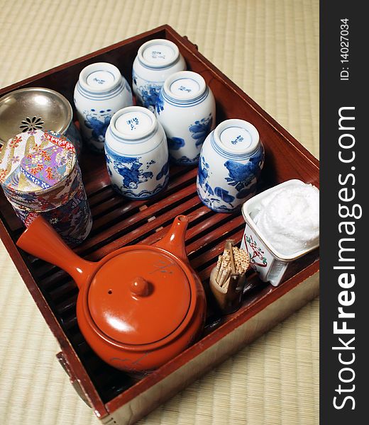 Japanese style tea set including cups, teapot, tea cans, towel, toothpicks in a wooden rack