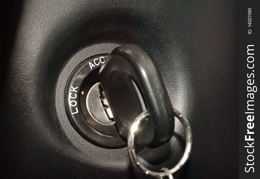 Black ignition key inserted into ignition slot. Black ignition key inserted into ignition slot