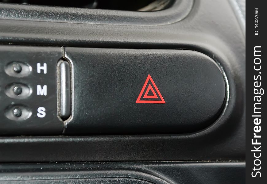 Black rounded emergency button with red triangles