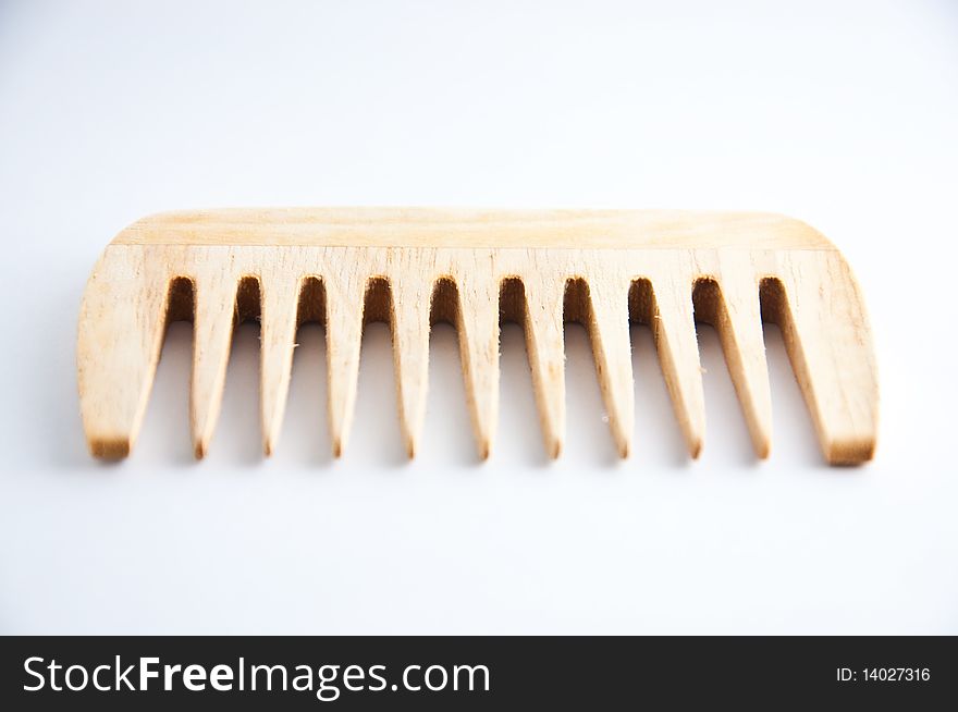 An ethnic wooden comb on a white background. An ethnic wooden comb on a white background.