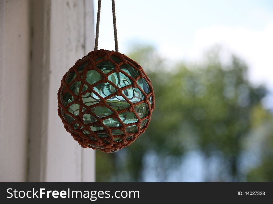 Old glass fishing bouy hanged up for decoration