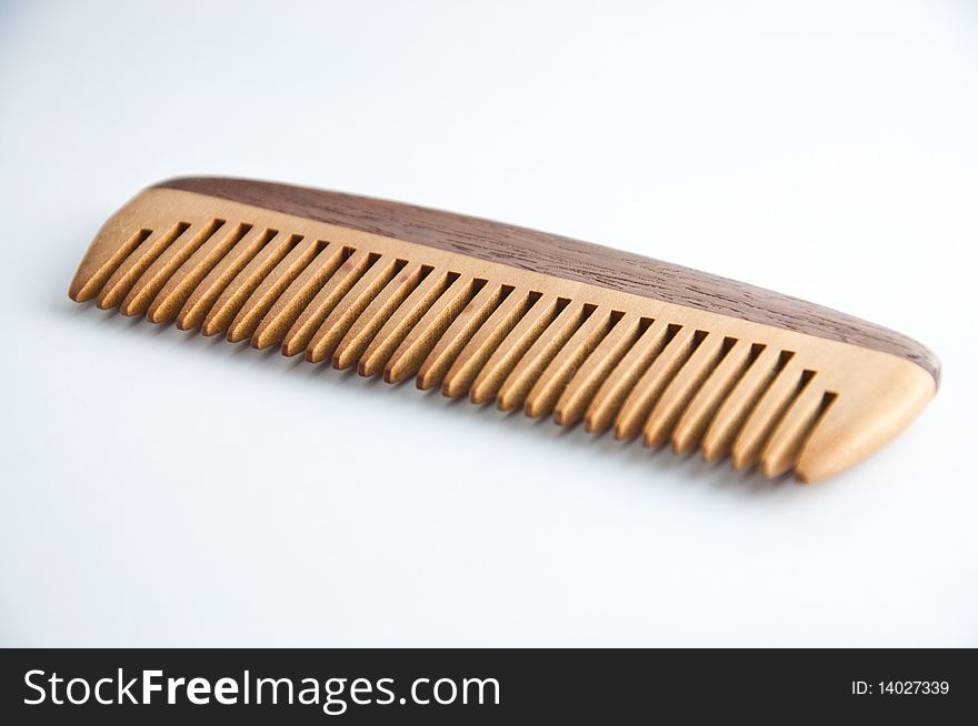 An ethnic wooden comb on a white background. An ethnic wooden comb on a white background.