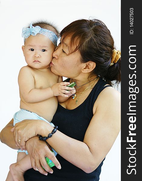 Mother holding baby kissing cheek. Mother holding baby kissing cheek