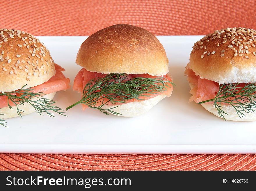 Smoked salmon party buns on a white rectangular plate. Smoked salmon party buns on a white rectangular plate