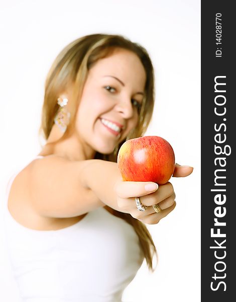 Woman showing an apple and smiling, white background, selective focus. Woman showing an apple and smiling, white background, selective focus