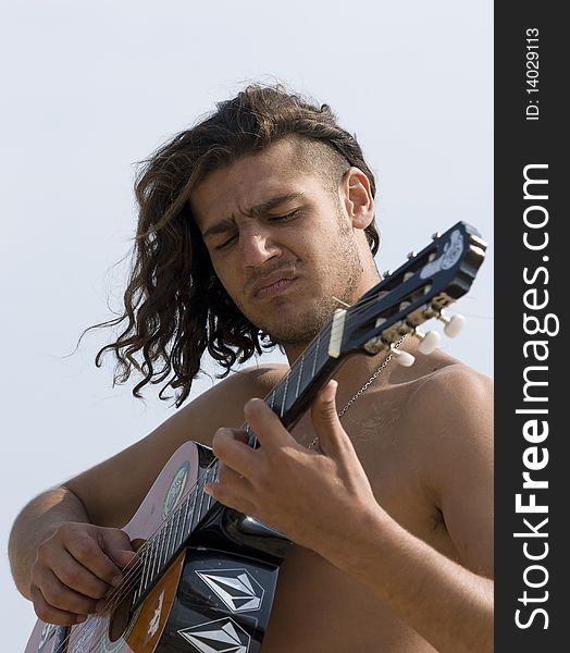 Young man playing the guitar on the beach. Young man playing the guitar on the beach