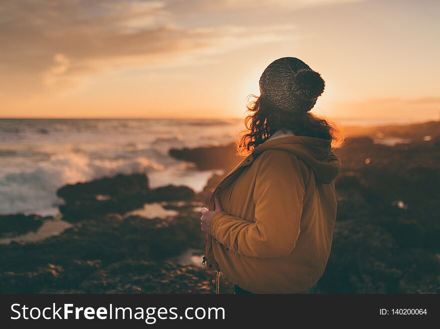 Woman in autumn by the sea at sunset. Woman in autumn by the sea at sunset