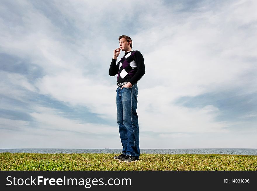 Young Man In The Clouds On The Green Grass