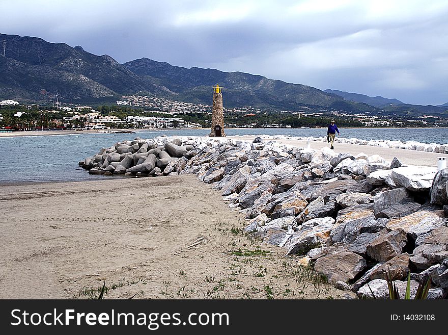 Lighthouse at end of jetty on beach