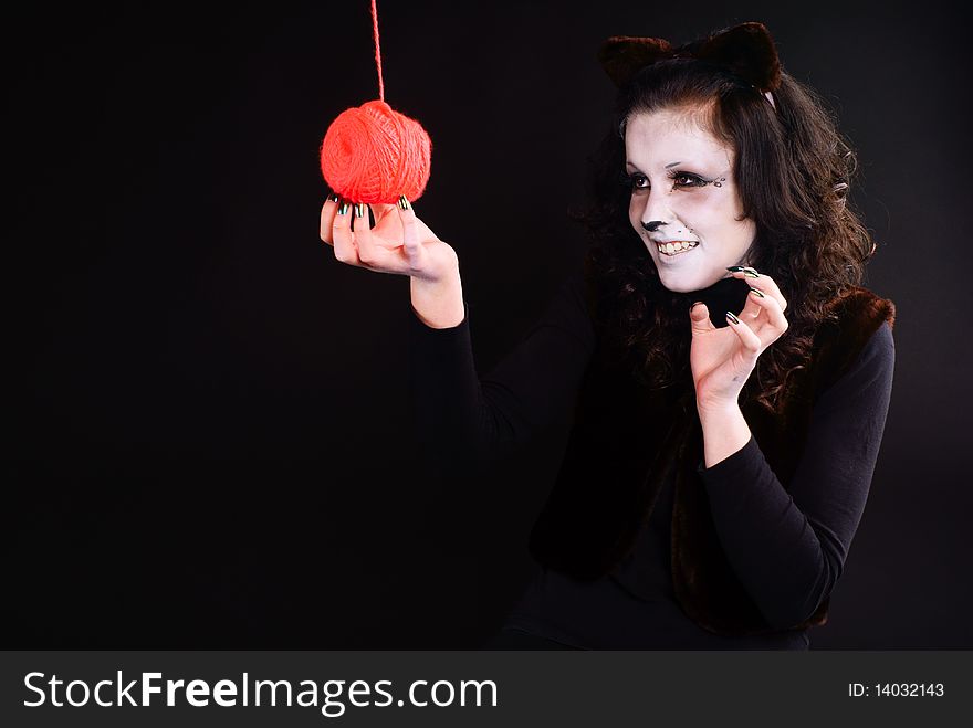 Cat-girl playing with threads ball. Studio shot. Cat-girl playing with threads ball. Studio shot.