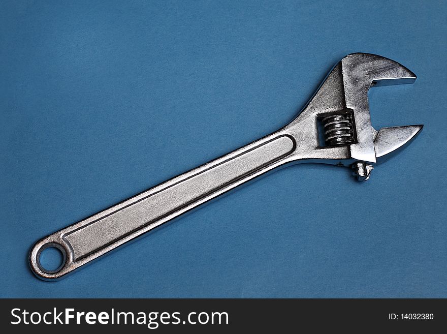 Adjustable steel wrench on blue background. Adjustable steel wrench on blue background