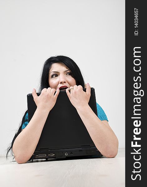 Stressed woman holding a laptop with hands and looking away with a scared face.Check also Facial expressions and gesture. Stressed woman holding a laptop with hands and looking away with a scared face.Check also Facial expressions and gesture