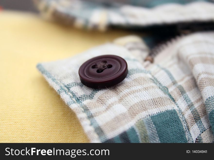 A button and zipper of a baby with a full tummy is open