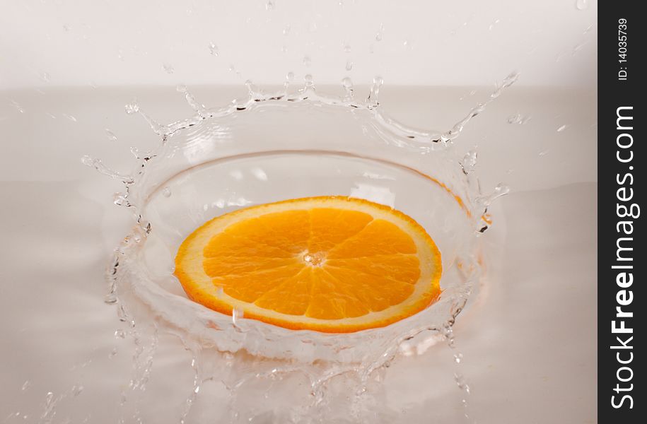 Orange slice under flowing water - concept of refreshment