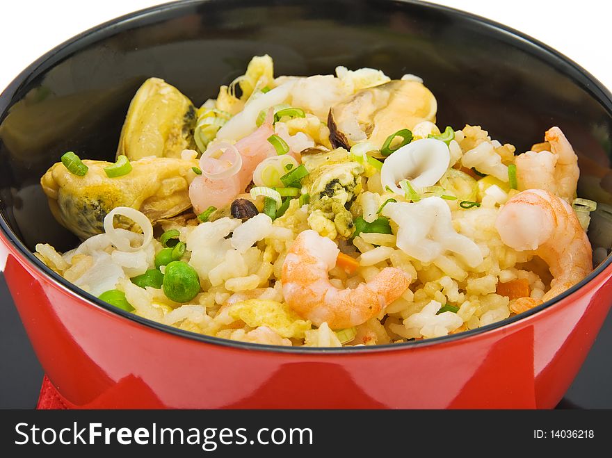 Black plate with rice and seafood on white