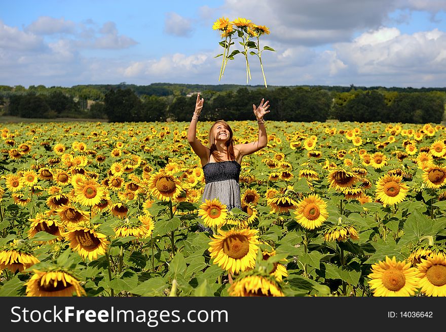 A young happy woman in a field of sunflowers. A young happy woman in a field of sunflowers