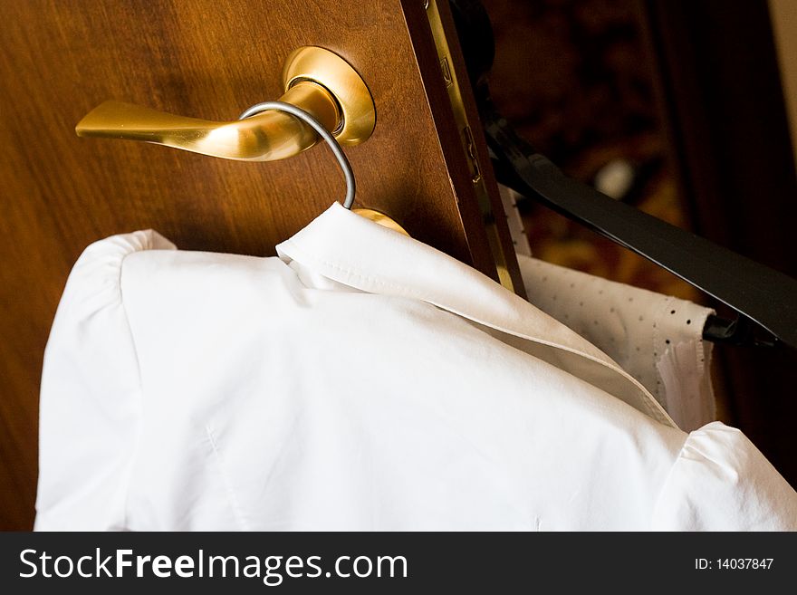 Female blouse on a hanger in room