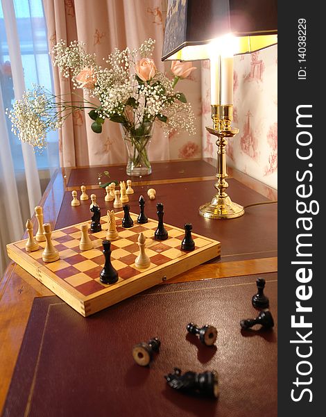 table with chess, flowers and lamp