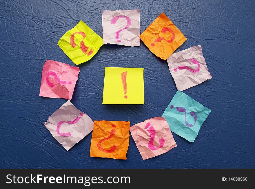 Sticker notes with exclamation and question signs over blue leather background. Sticker notes with exclamation and question signs over blue leather background