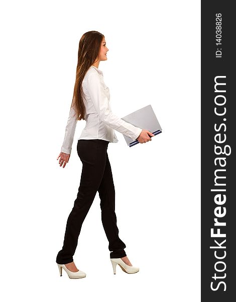 A young businesswoman walking and holding a laptop, isolated on white background. A young businesswoman walking and holding a laptop, isolated on white background
