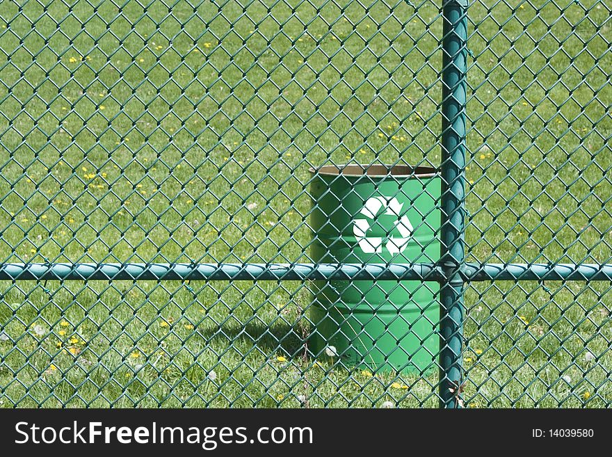 Green recyling bin in a park. Green recyling bin in a park