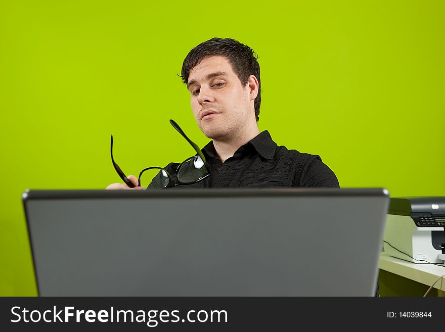 Young man sitting in the office and working on the laptop. Young man sitting in the office and working on the laptop