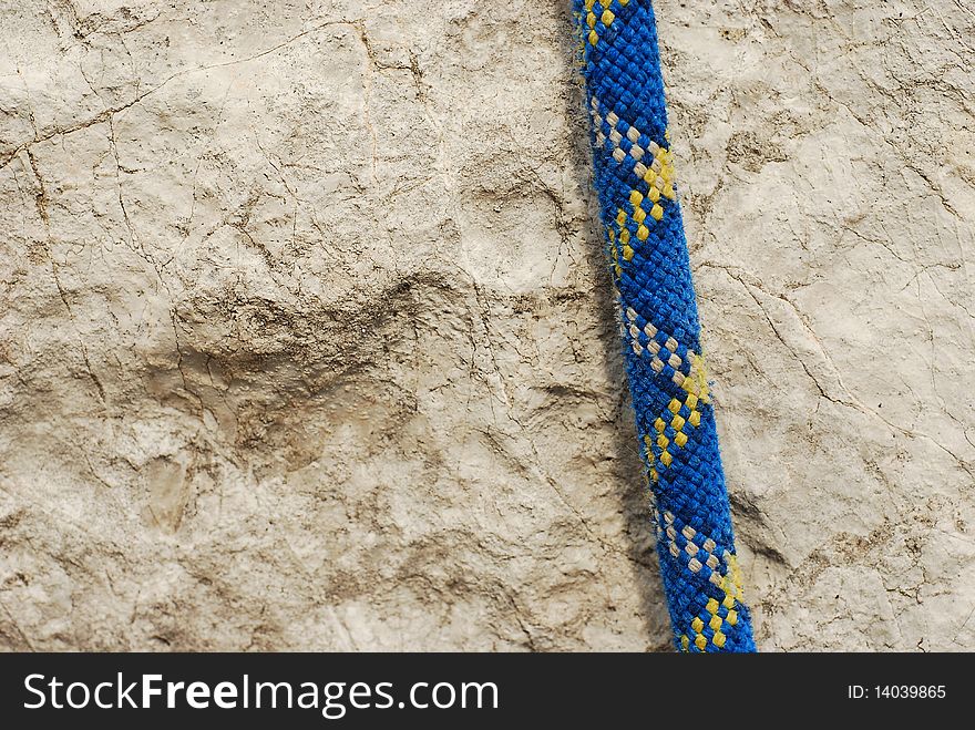 Detail of a blue climbing rope over the stone. Detail of a blue climbing rope over the stone