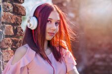 Gorgeous Redheads Lady Listening Music In Headphones On Blurred Background And Red Wall Bricks In Sunset Stock Images Gorgeous Redheads Lady Listening Music In Headphones On Blurred Background And Red Wall Bricks In Sunset Stock Images