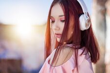Gorgeous Redhead Lady Listening Music In Headphones On Blurred Background Outdoor Stock Photography Gorgeous Redhead Lady Listening Music In Headphones On Blurred Background Outdoor Stock Photography