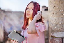 Redhead Woman With Headphones Using Tablet And Listening To Music On Old Ruins Building Royalty Free Stock Photos Redhead Woman With Headphones Using Tablet And Listening To Music On Old Ruins Building Royalty Free Stock Photos