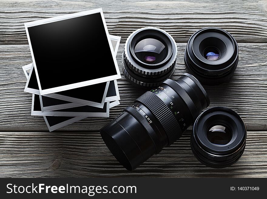 Lenses and photo frames on old wooden table