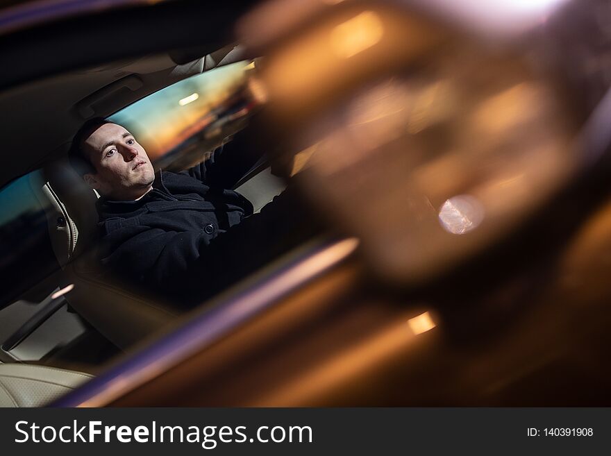 Handsome young man driving his car at night