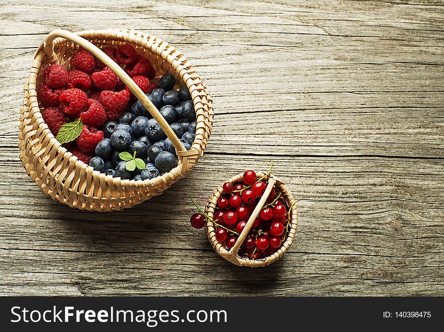 Mix of fresh berries fruit in a basket on wooden background. Mix of fresh berries fruit in a basket on wooden background