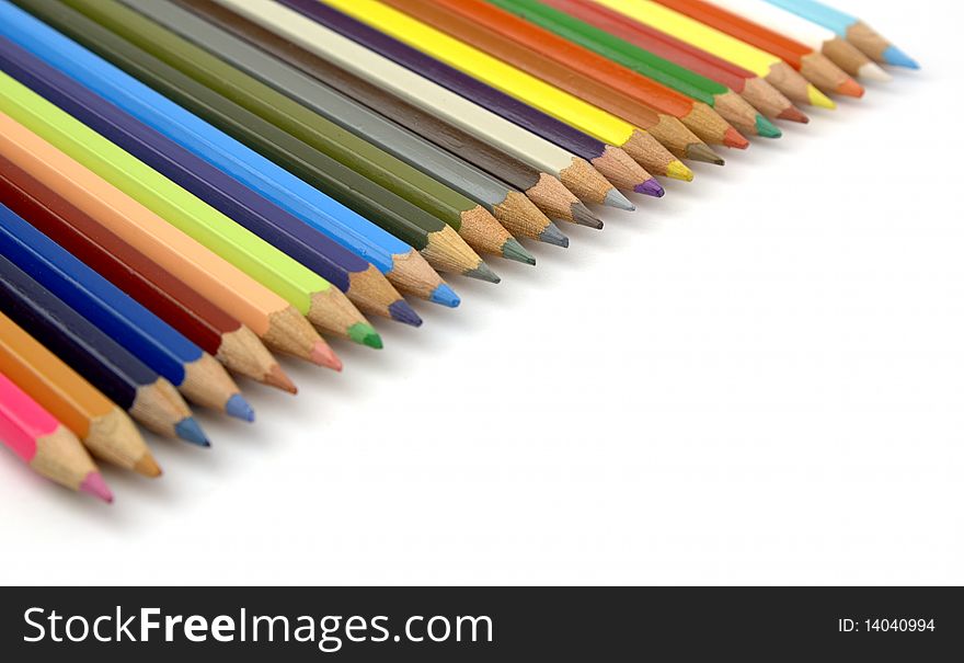 Pencils of various colors in diagonal on a white background