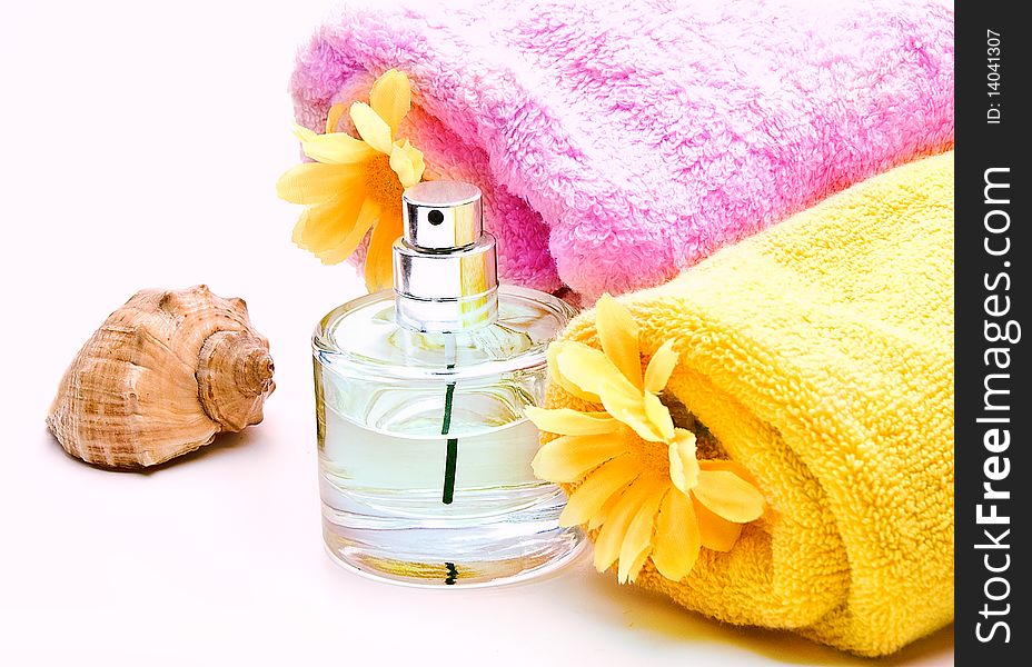 Spa towels with flower and bottle of perfume