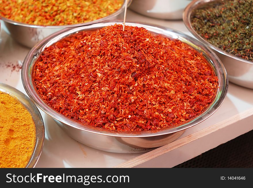 Colorful spices in bowl on market stand