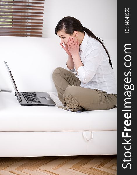 Happy attractive young woman at sofa with laptop. Happy attractive young woman at sofa with laptop