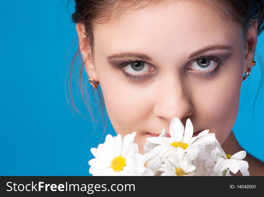 Close-up beautiful fresh young brunette smiling in studio shot with camomile. Close-up beautiful fresh young brunette smiling in studio shot with camomile