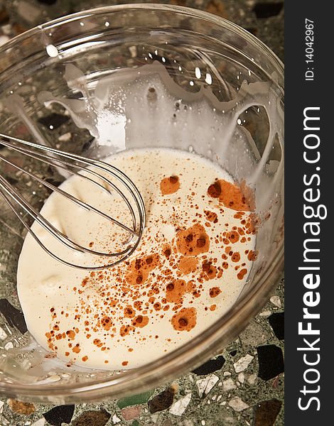 Whipping cream, whisk in a glass dish on kitchen