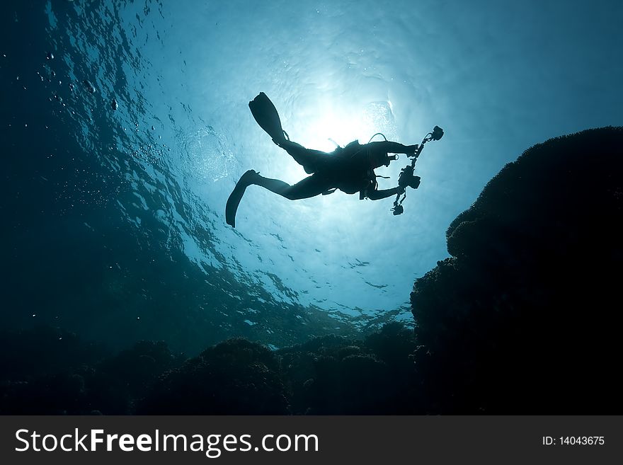 Silhouette of an underwater photographer