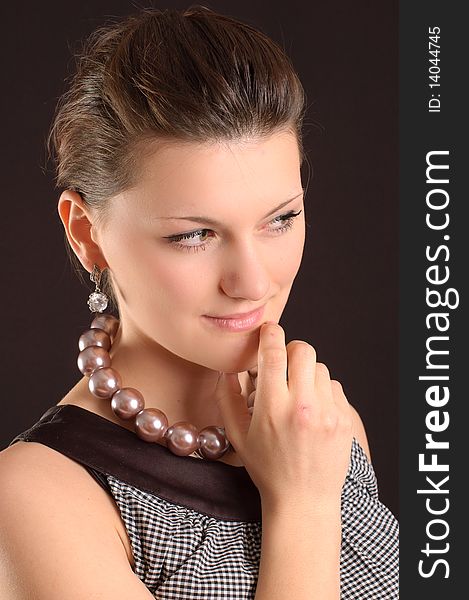 Portrait of a girl with beads in a dress in retro style on a black background