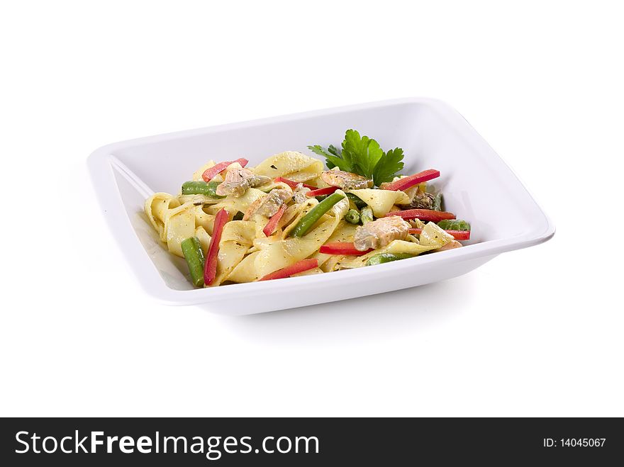 Pasta with salmon in bowl on white ground