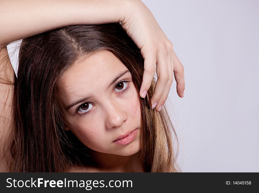 Portrait of young girl put hand on head on gray background