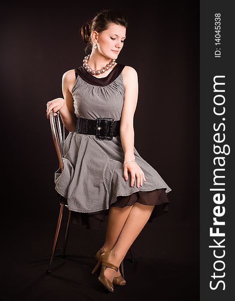 Portrait of a girl with beads in a dress in retro style on a black background