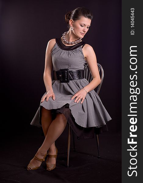 Portrait of a girl with beads in a dress in retro style on a black background