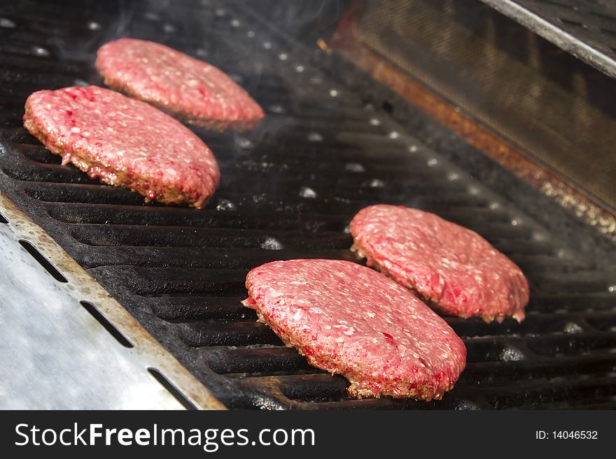 Lean ground beef cooking on the grill of a bbq. Lean ground beef cooking on the grill of a bbq