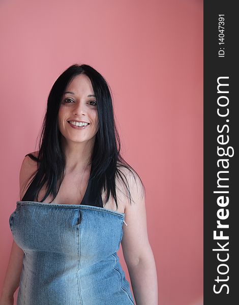 Smiling girl dressed in her jeans behind a pink background. Smiling girl dressed in her jeans behind a pink background