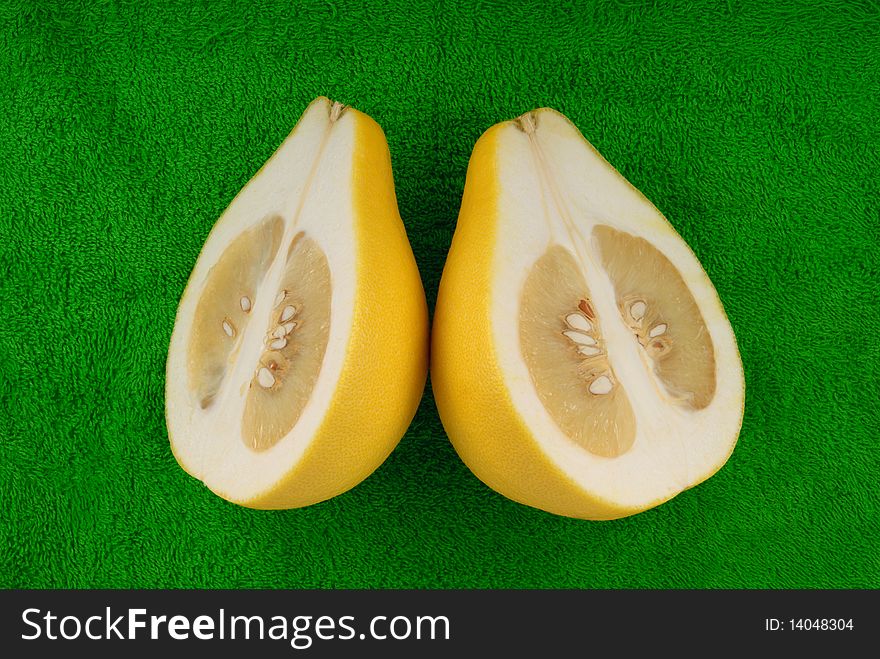 Two halves of fruit pomelo lie on green towel